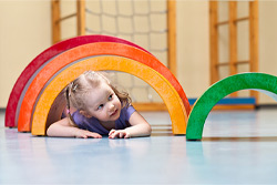 Junge Patientin krabbelt durch einen Regenbogentunnel