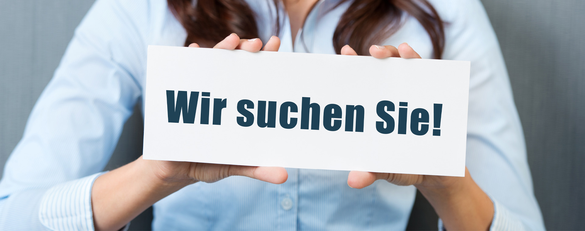 Frau mit einem Schild mit der Aufschrift: Wir suchen Sie!